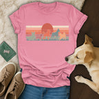 Pink t-shirt with silhouette dogs against a retro sunset graphic.