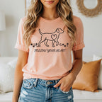 Peach t-shirt with a minimalist dog outline, heart, and paw prints. Text says "FOLLOW YOUR HEART".