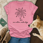 Pink t-shirt with fireworks and a dog silhouette, text "one nation, under dogs".