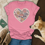 Pink t-shirt with embroidered heart filled with dog toys and paws.