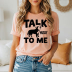 Peach t-shirt with black text and a howling husky graphic.