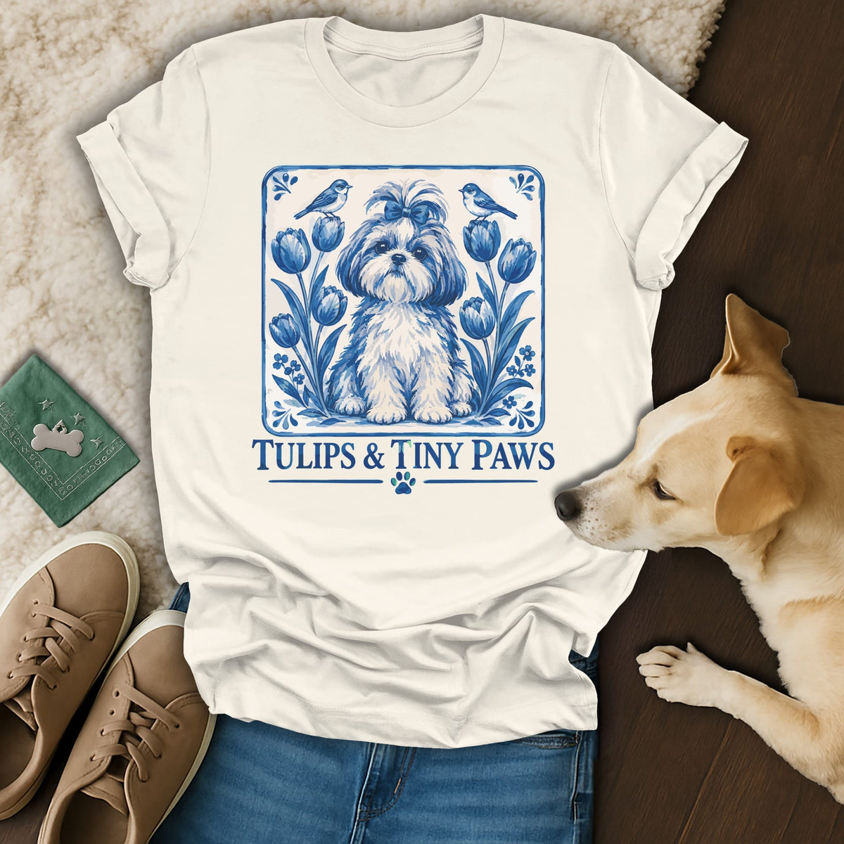 Off-white t-shirt with a blue graphic of a dog, tulips, and birds, featuring the text "Tulips & Tiny Paws".