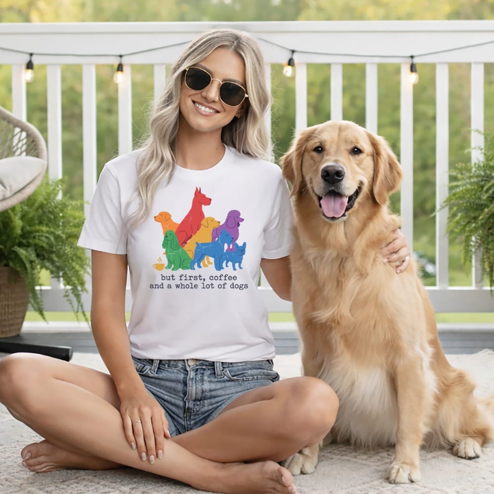White t-shirt with colorful dog illustrations and text reading "but first, coffee and a whole lot of dogs".