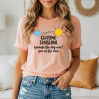 Peach t-shirt with "Chasing Sunshine Because The Dog Won't Poo In The Rain" text.