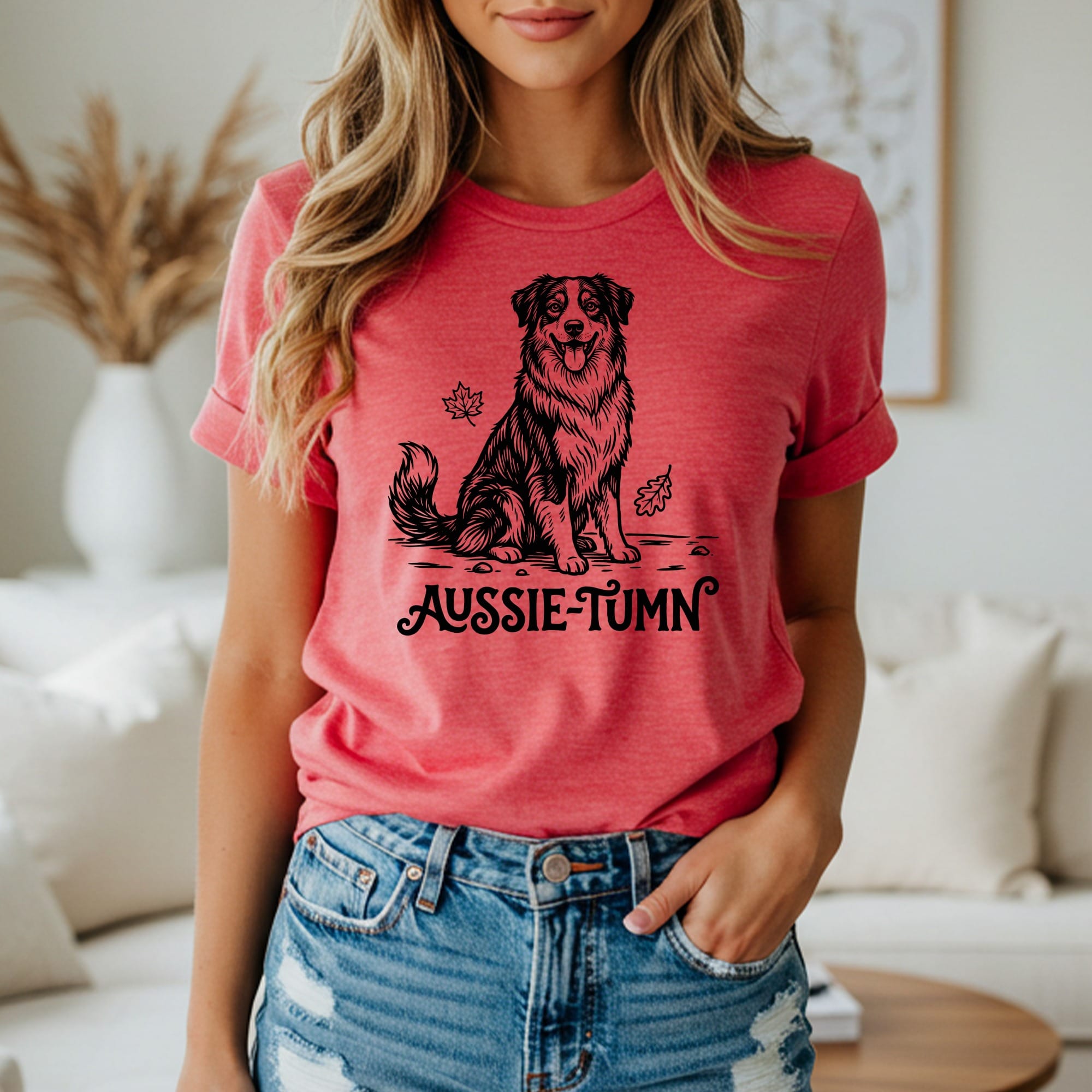 Black line art of an Australian Shepherd dog sitting with leaves, text "Aussie-Tumn" below.