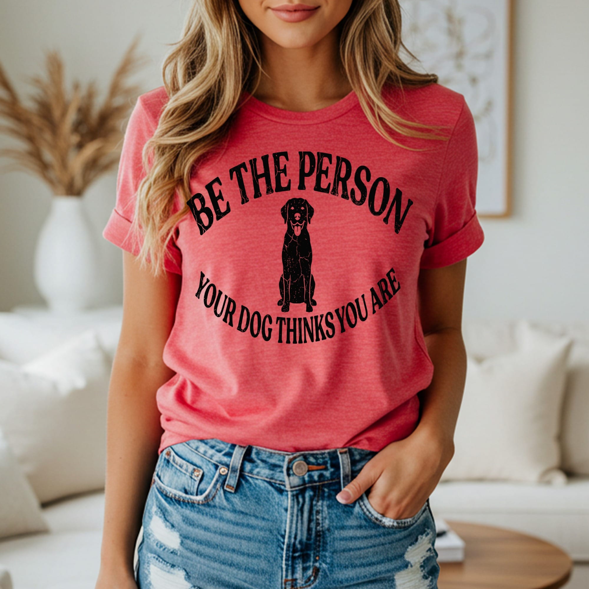 Woman wearing coral t-shirt with black dog silhouette and text.