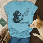 T-shirt with dachshund blowing dandelion puffs, "Wiener Wishes" text.
