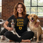 Woman holding two dogs, one black and white, one yellow lab, wearing a shirt with "Rescue. Love. Repeat."