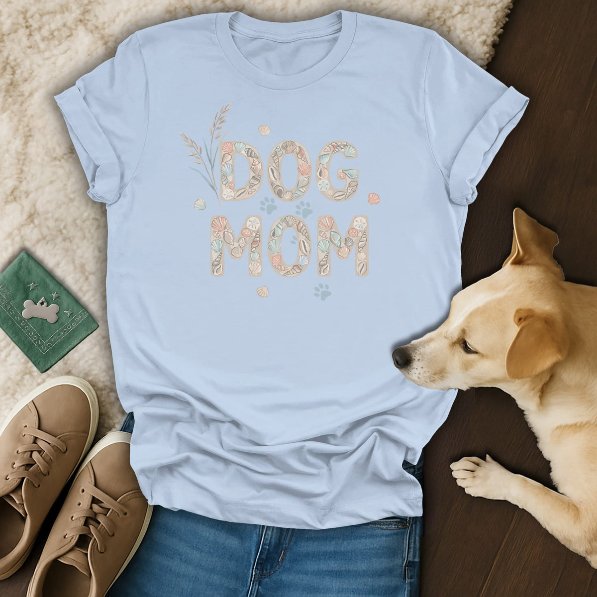 Light blue t-shirt with "Dog Mom" graphic made of seashells and sand dollars.