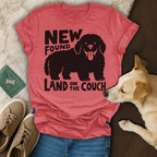 Red t-shirt with "NEW FOUND LAND ON THE COUCH" text and dog graphic.