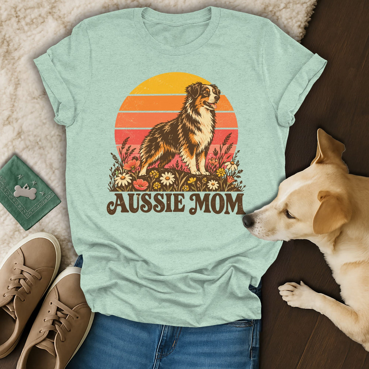 Light green t-shirt with a retro Australian Shepherd sunset graphic and the text Aussie Mom.