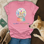 Pink t-shirt with a watercolor snow globe of paw prints and flowers, and text.