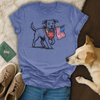 Dog wearing bandana holds American flag, printed on a blue t-shirt.
