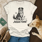 Cream t-shirt with black line art of a smiling Australian Shepherd and "Aussie-Tumn" text.