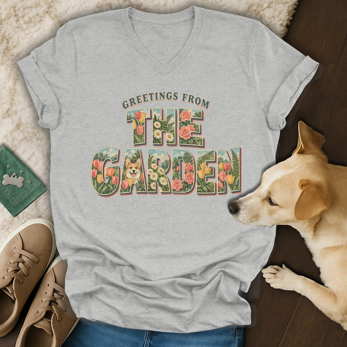 Heather gray v-neck t-shirt featuring a vintage floral graphic with text reading Greetings from the Garden, surrounded by a dog and shoes.