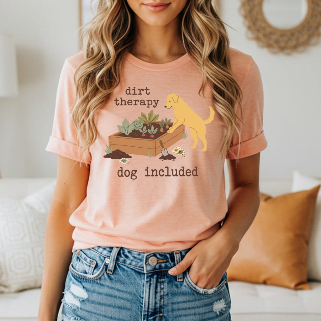 Peach t-shirt with "dirt therapy dog included" text and a golden retriever by a garden box.