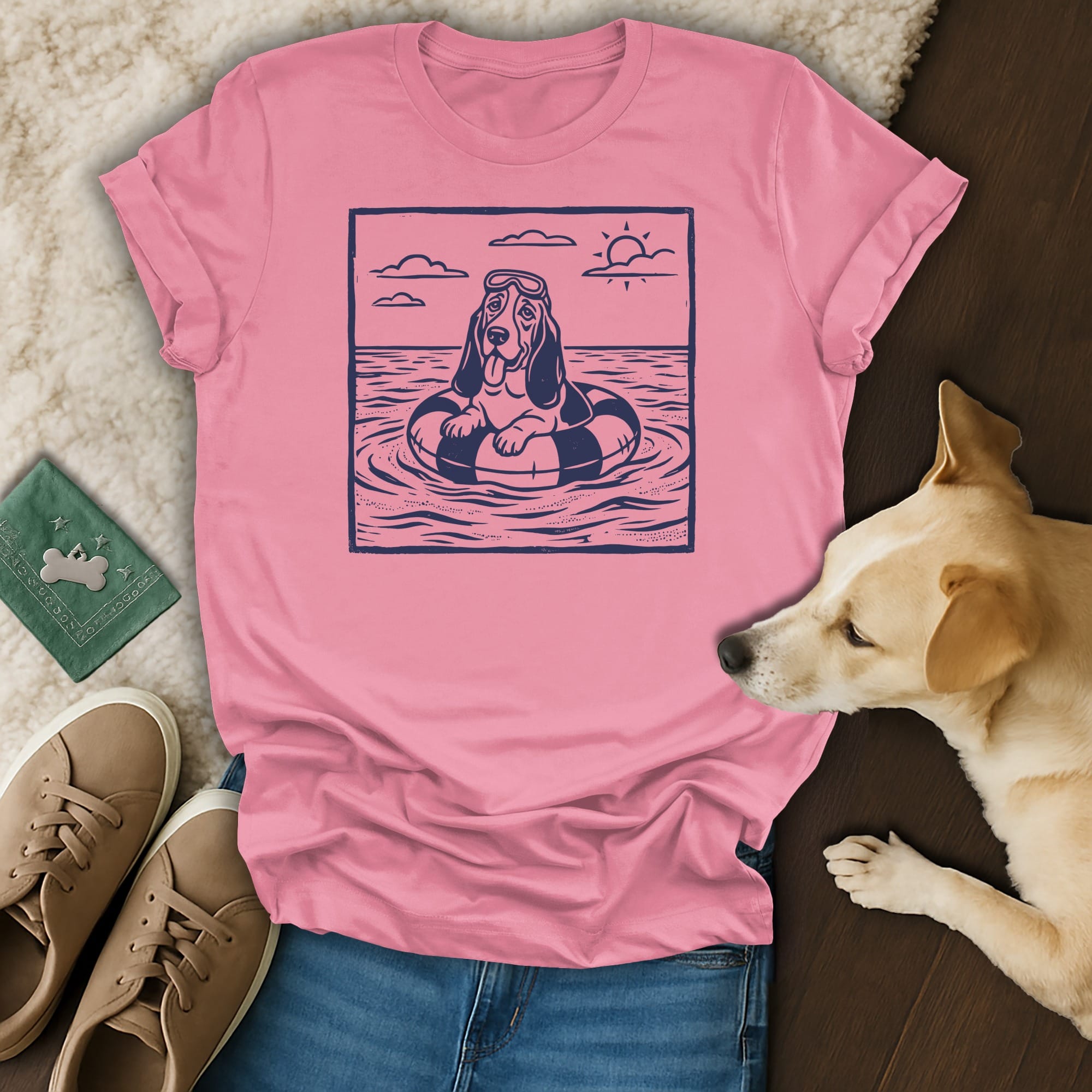 Pink t-shirt with graphic of dog in inner tube on the ocean.