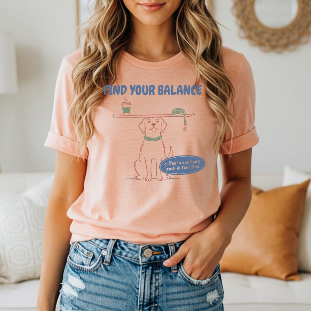 Peach t-shirt with a dog balancing coffee and leash, says "Find Your Balance".