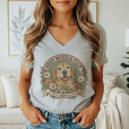 A person wearing a grey v-neck t-shirt featuring a vintage Golden Retriever graphic and the text Grey Muzzle Club.