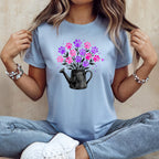 Light blue t-shirt with black watering can and pink and purple paw prints.