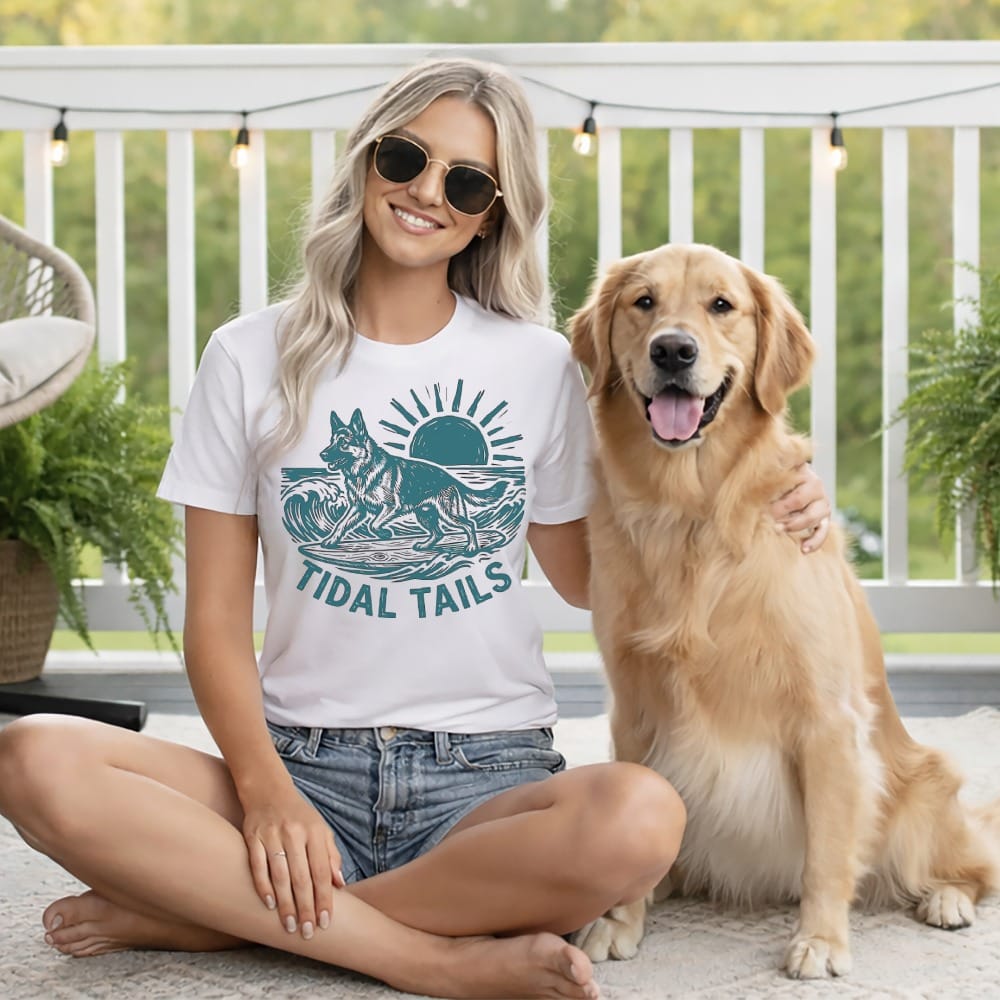 Woman in t-shirt with "TIDAL TAILS" and a sun/wave graphic, with a golden retriever.