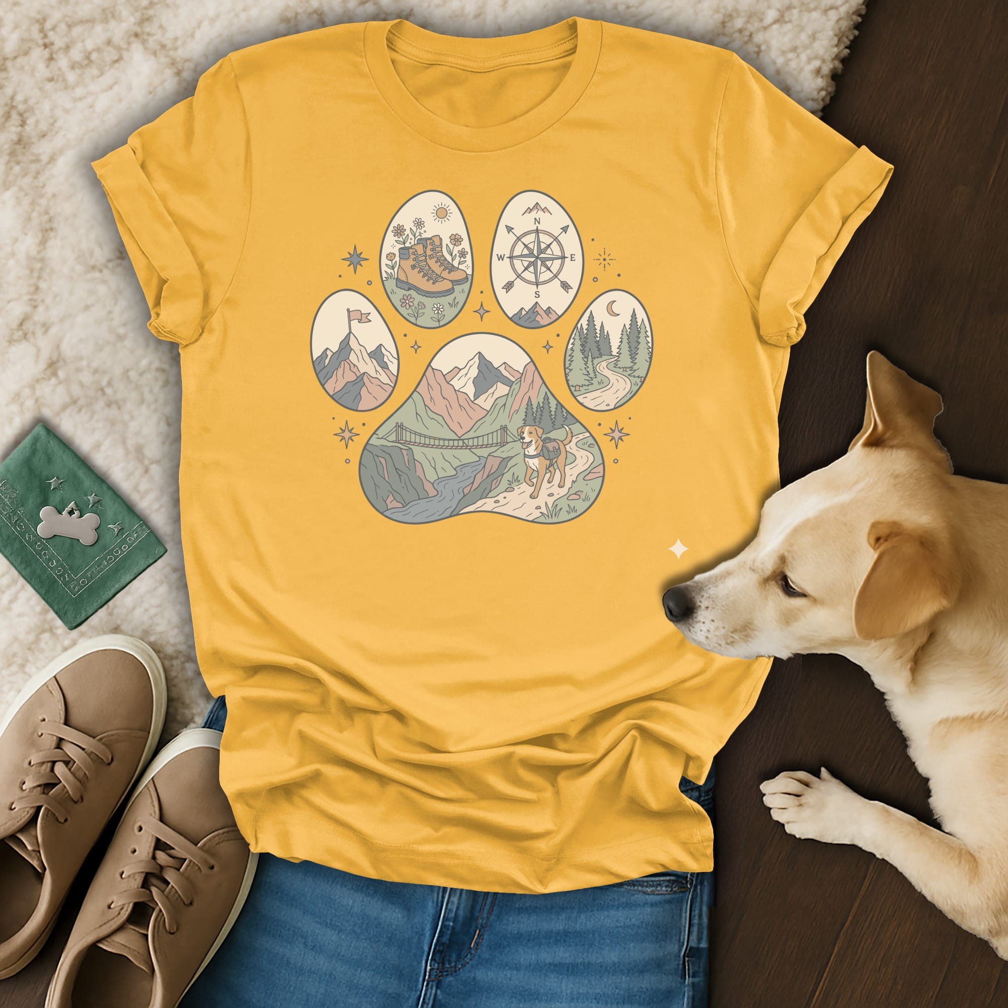 Yellow t-shirt with a paw print design featuring outdoor adventure scenes.