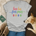 Grey t-shirt with rainbow text "love has four paws" and paw prints.