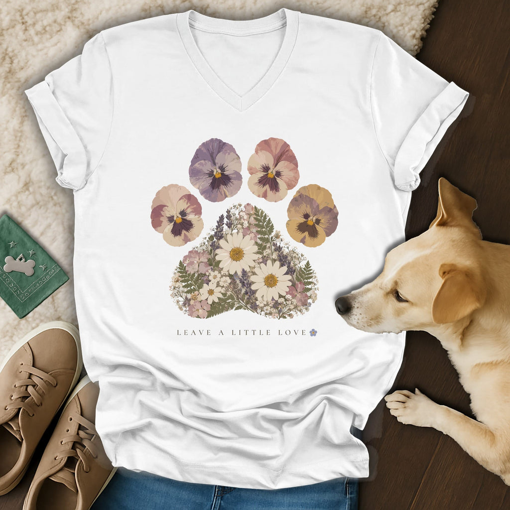 A white V-neck t-shirt featuring a floral paw print graphic with the text "Leave a Little Love."