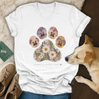 A white V-neck t-shirt featuring a floral paw print graphic with the text "Leave a Little Love."