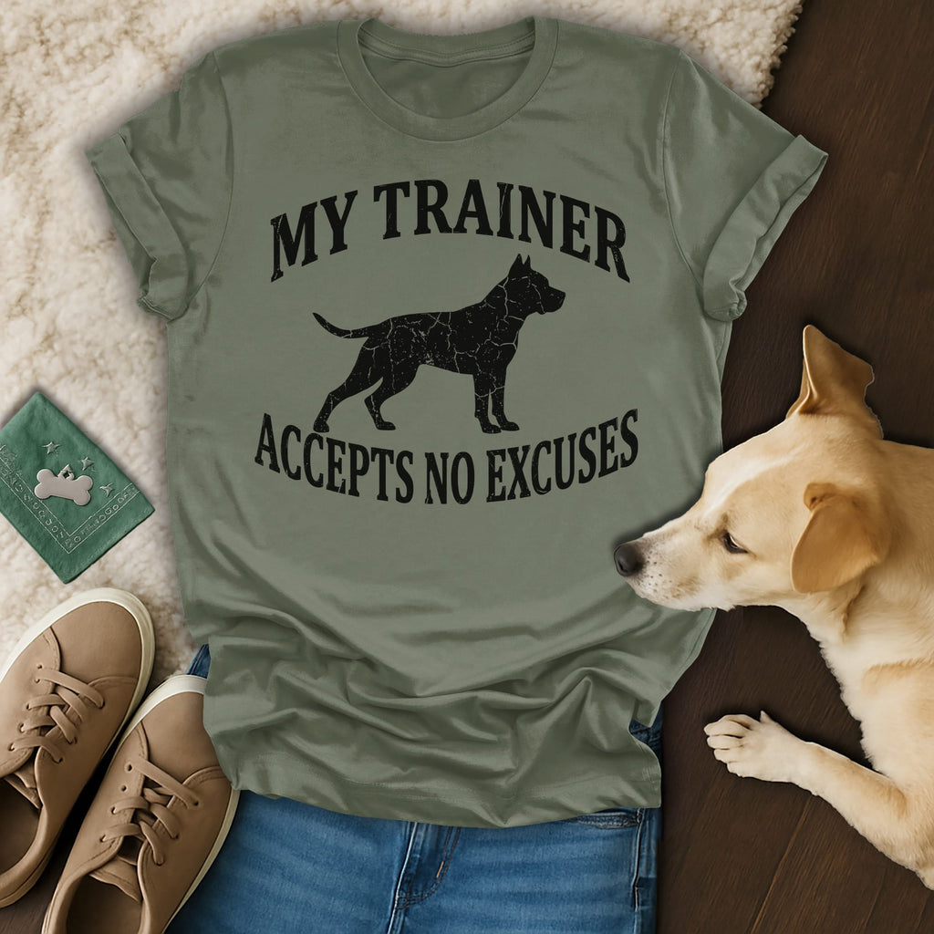 Olive green t-shirt with black dog silhouette and text "MY TRAINER ACCEPTS NO EXCUSES".