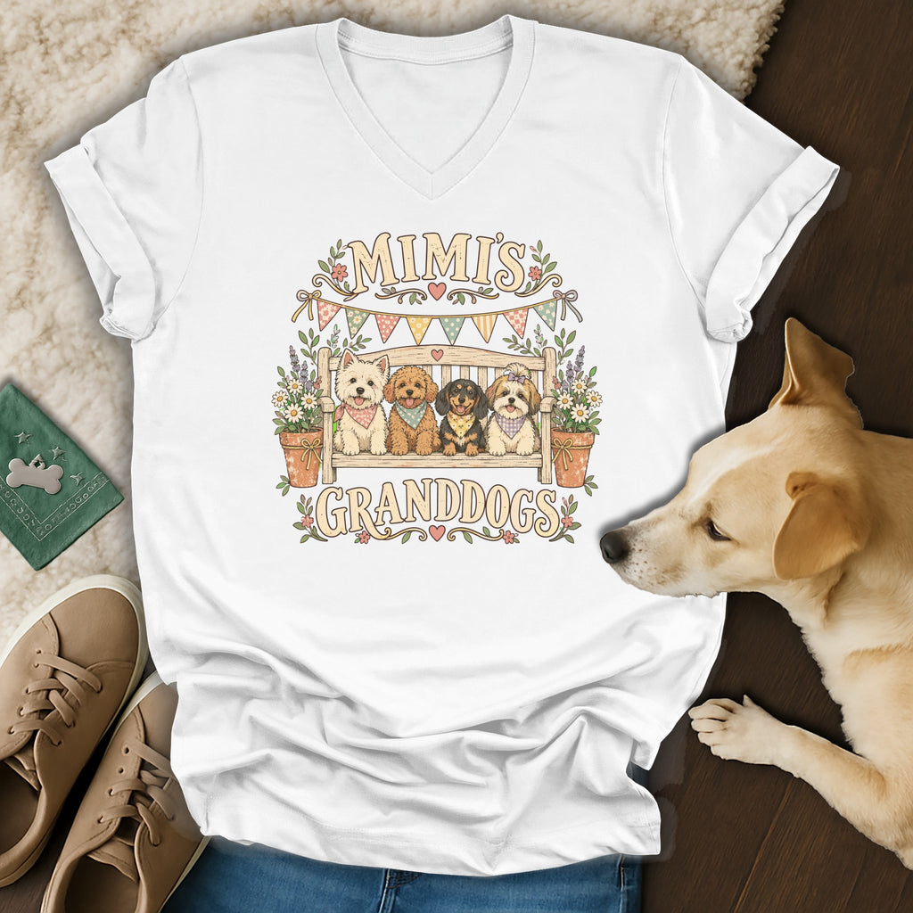 A white V-neck t-shirt featuring a graphic of four dogs on a bench with text reading MIMI'S GRANDDOGS.