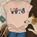 Four dog heads wearing colorful beanies on a pink t-shirt.
