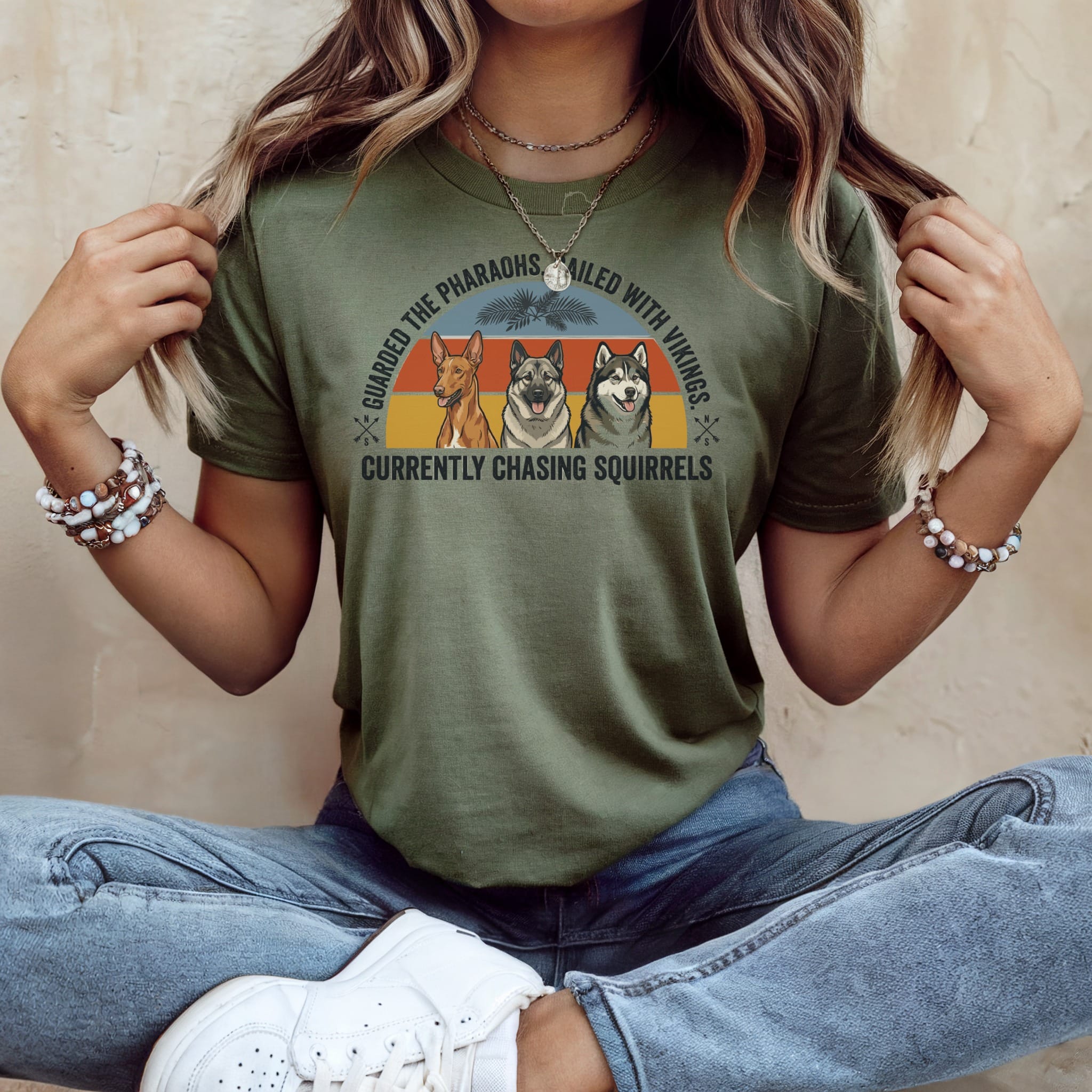 Green t-shirt with three dogs and text about guarding pharaohs.