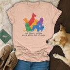 Peach t-shirt with colorful dogs and text "but first, coffee and a whole lot of dogs".