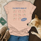 Peach t-shirt with "I'M PRETTY GOOD AT winging it." text and cartoon dogs.