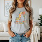 Grey t-shirt with colorful dog sniffing a flower and text "STOP AND SNIFF THE FLOWERS."