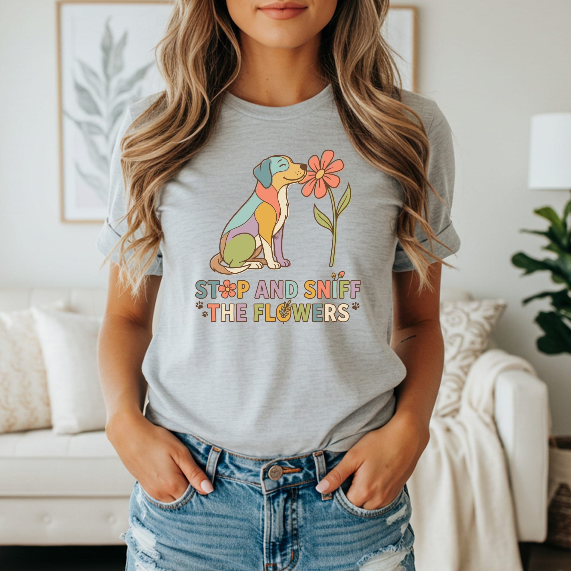 Grey t-shirt with colorful dog sniffing a flower and text "STOP AND SNIFF THE FLOWERS."