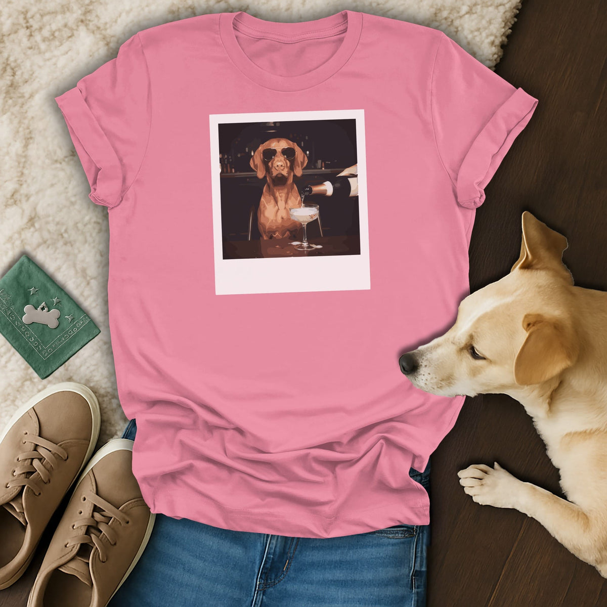 Pink t-shirt with a graphic of a dog in sunglasses being poured champagne.