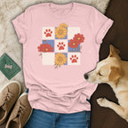 Pink t-shirt with a grid of red paw prints and colorful flowers.