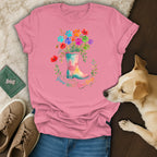 Pink t-shirt with colorful paw prints and flowers in a boot, says "Grow Wild Love Dogs".