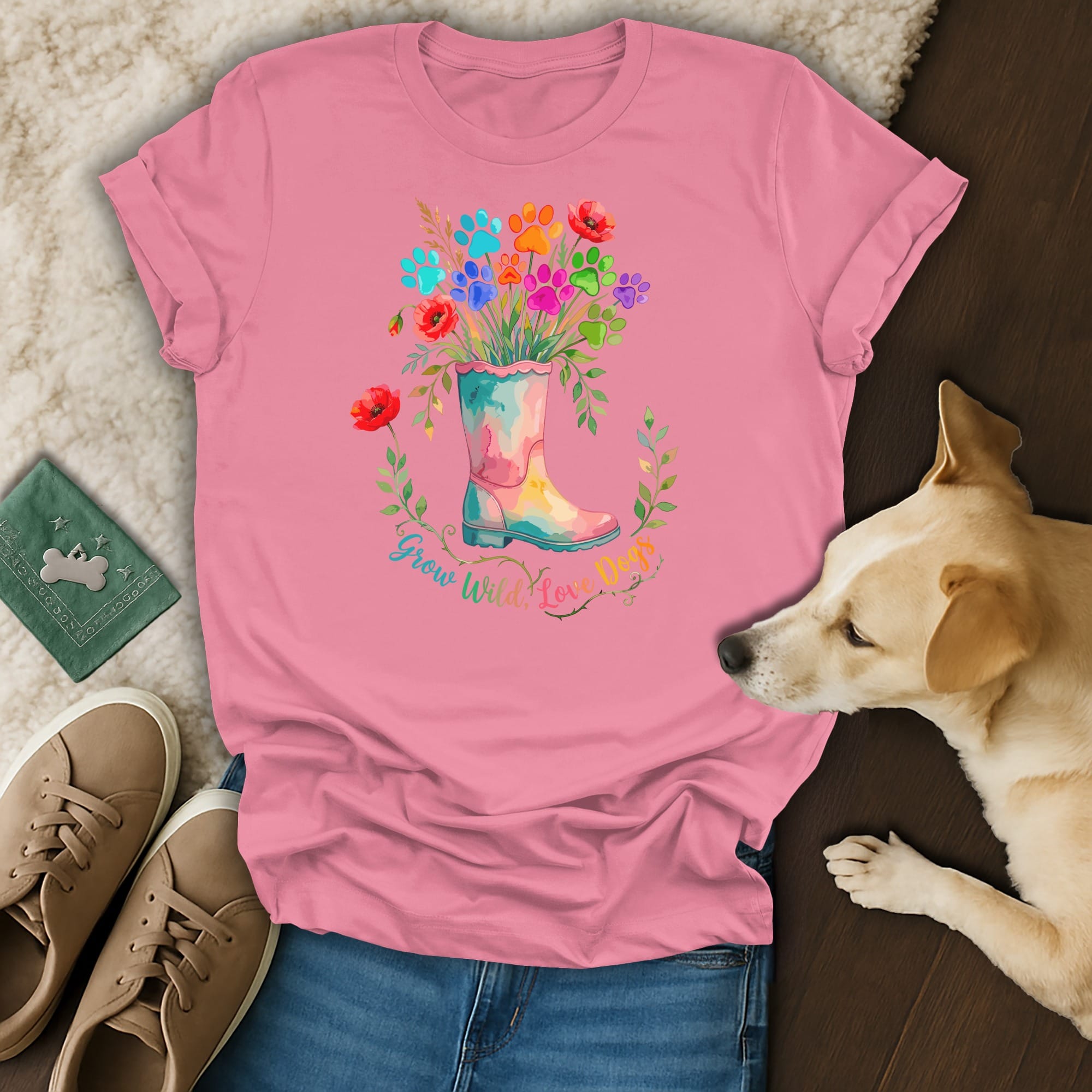 Pink t-shirt with colorful paw prints and flowers in a boot, says "Grow Wild Love Dogs".