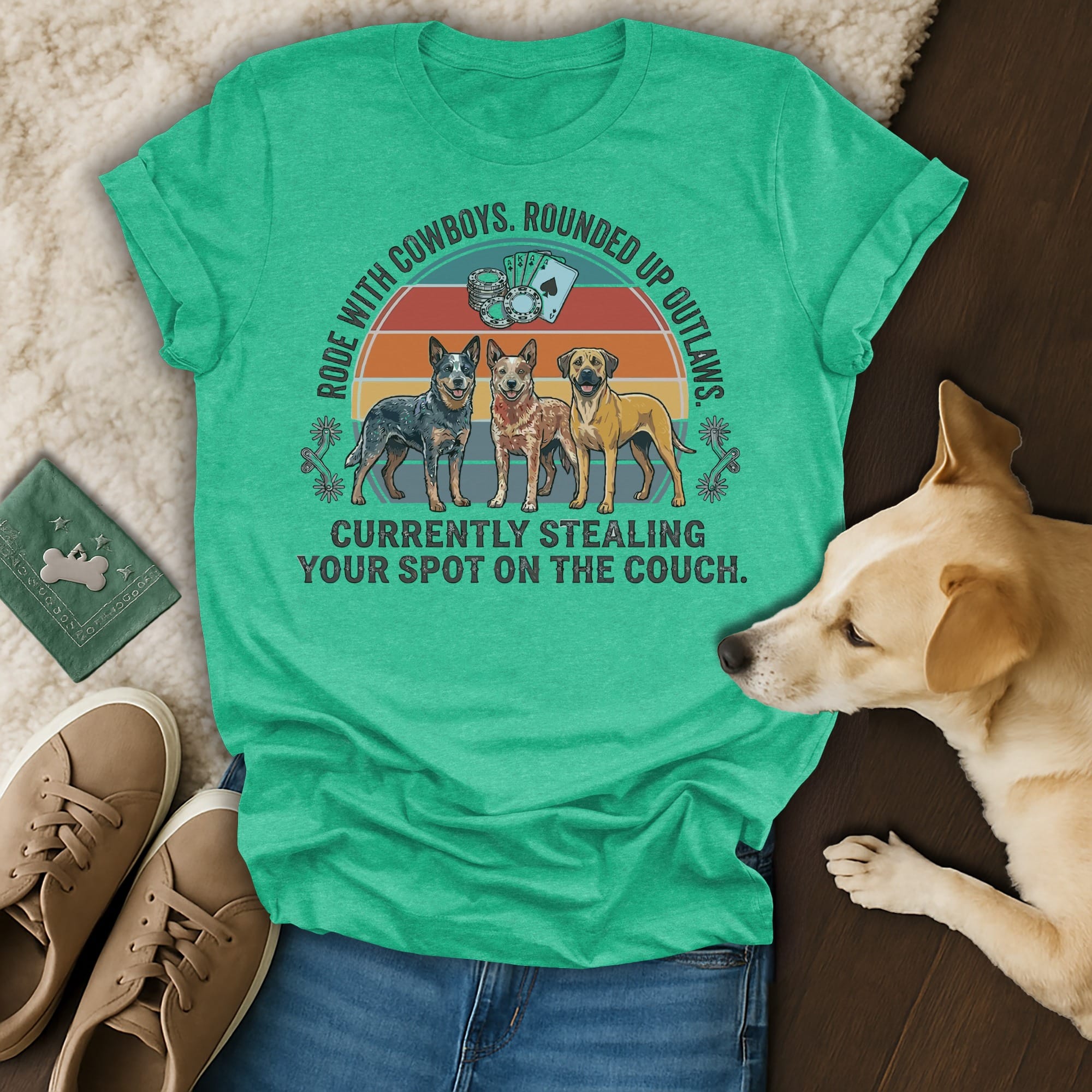 Green t-shirt with three dogs, text reads: "Rode with cowboys. Rounded up outlaws. Currently stealing your spot on the couch."
