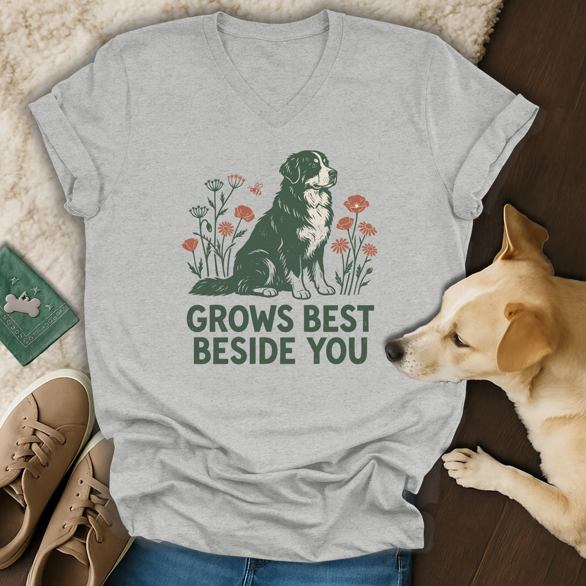 A gray v-neck t-shirt features a graphic of a Bernese Mountain Dog surrounded by flowers and the text GROWS BEST BESIDE YOU.
