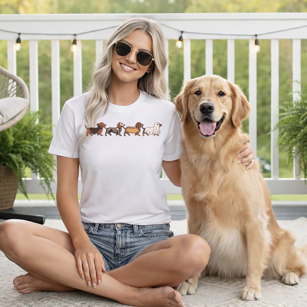 Woman in white t-shirt with dachshund graphic and golden retriever dog outdoors