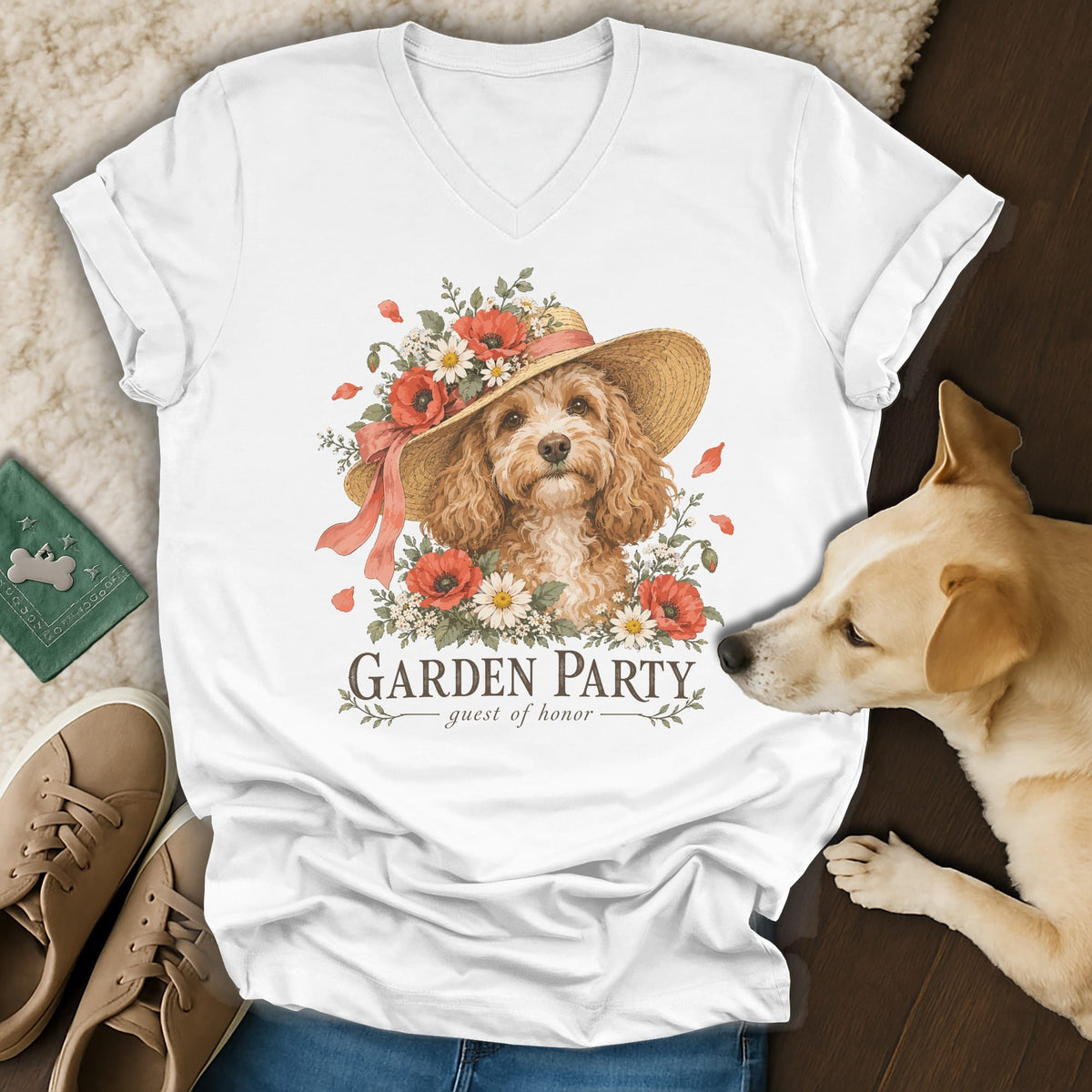 A white V-neck t-shirt featuring a graphic of a poodle wearing a floral sun hat and the text "Garden Party."