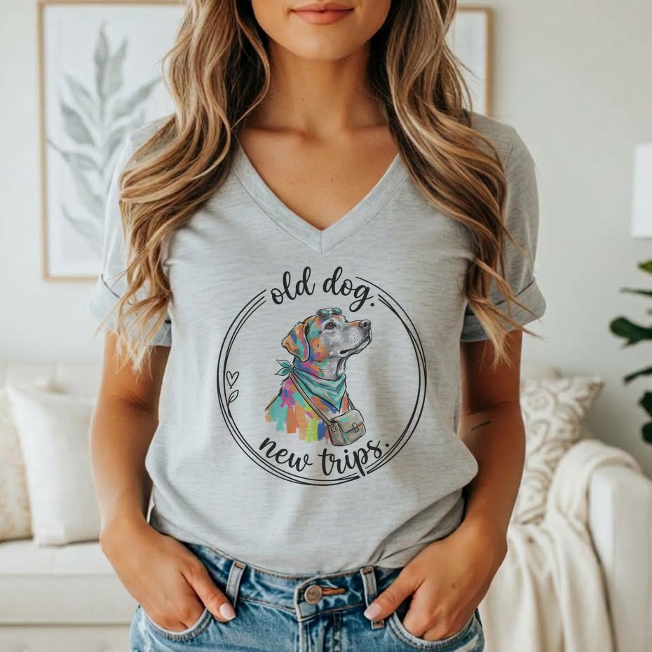 Gray t-shirt with a colorful dog wearing a bandana and bag, with text "old dog, new trips".