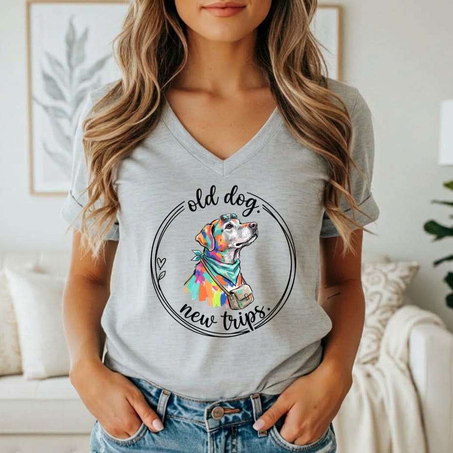 Gray t-shirt with a colorful dog wearing a bandana and bag, with text "old dog, new trips".
