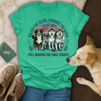 Green t-shirt with three dogs and text about sleds and table scraps.