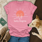 Pink t-shirt with sun and dog running design, "Salty Dogma" text.