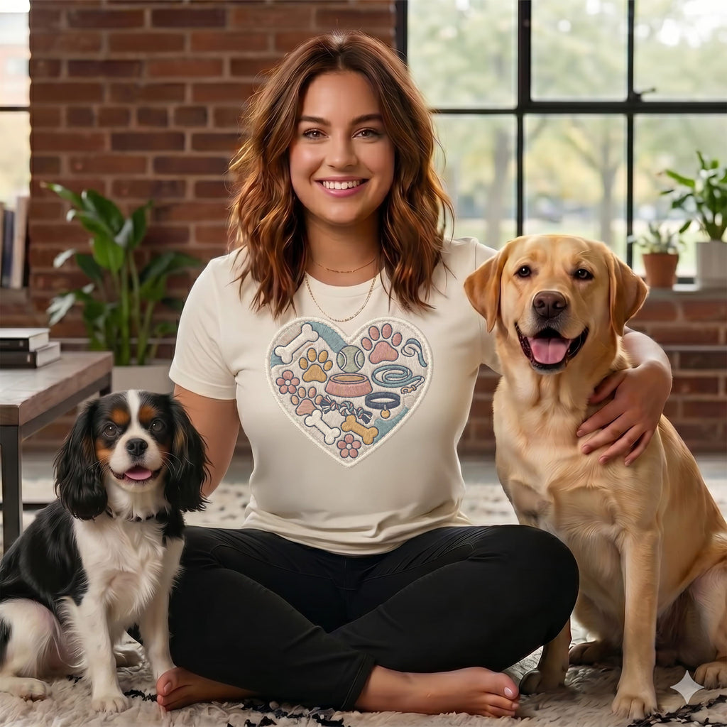 Woman with a Cavalier King Charles Spaniel and a Labrador Retriever, wearing a shirt with a heart design.